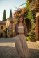 Model wearing cropped mocha linen jacket in Italian courtyard