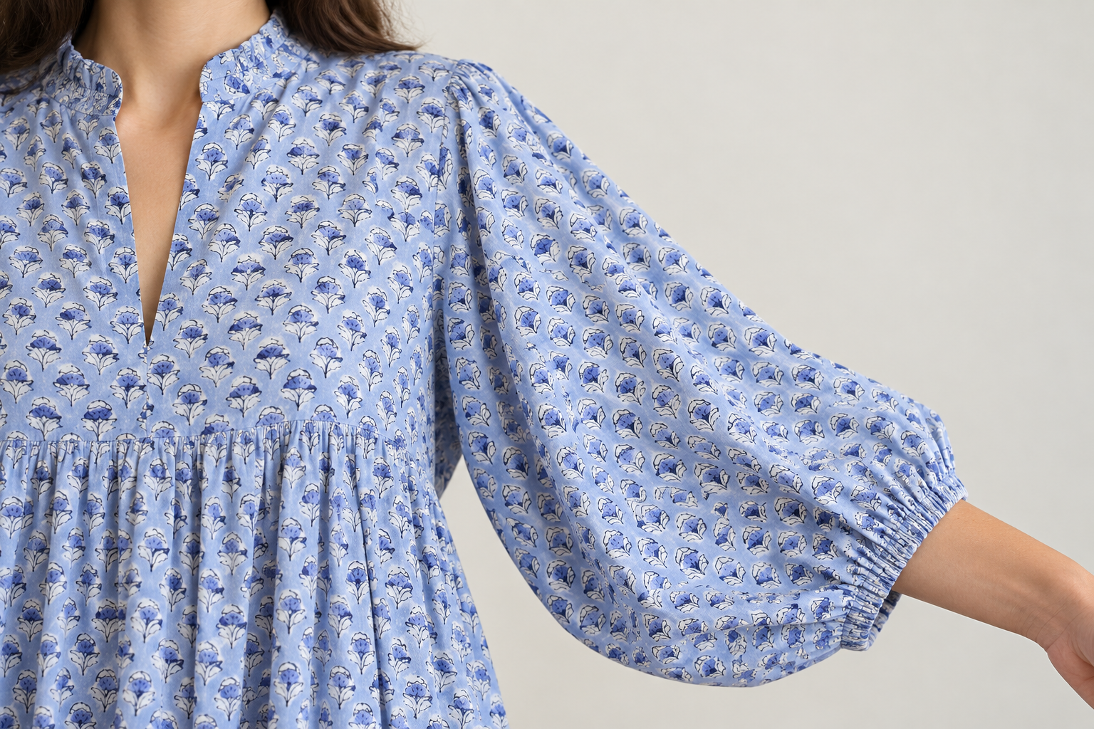 Lifestyle close-up showing the blue floral dress sleeve and elastic cuff