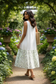 White linen tank slip dress with floral ruffle styled in natural setting