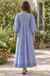 Model wearing blue floral block print dress loose without tie, back view with closed skirt